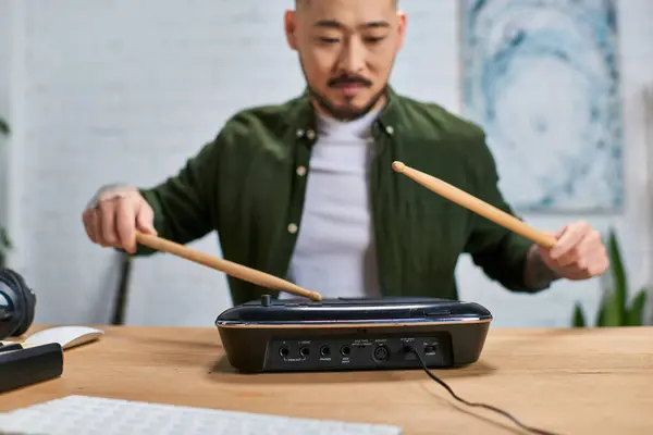 Un homme asiatique joue de la batterie électronique dans son studio. — Photo de stock
