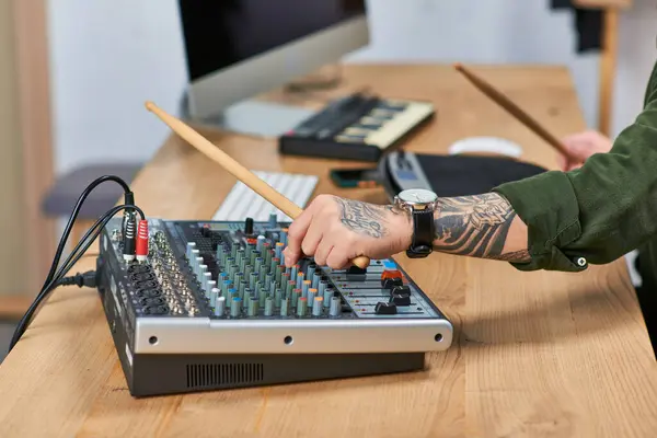 Um homem em um estúdio, ajustando um quadro de som com baquetas na mão. — Fotografia de Stock