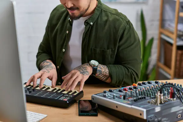 Un bel asiatico suona una tastiera MIDI nel suo studio. — Foto stock