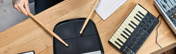 Un uomo suona un tamburo digitale mentre lavora in uno studio musicale. — Foto stock