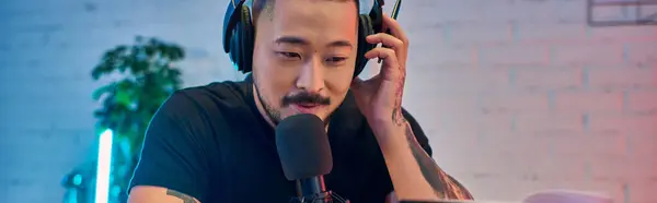 A man with headphones records a podcast in his studio. — Stock Photo