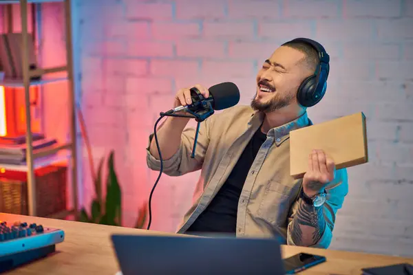 A young Asian man records a podcast in his home studio. — Stock Photo