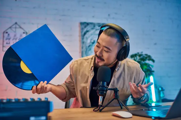 Ein Mann im Studio nimmt einen Podcast auf, während er eine Schallplatte hält. — Stockfoto