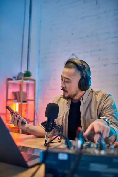 A handsome Asian man records a podcast in his home studio. — Stock Photo