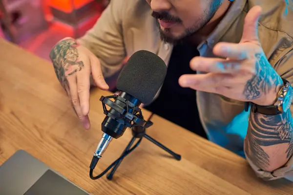 A man with tattoos records a podcast in his home studio. — Stock Photo