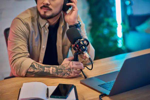 A handsome Asian man records a podcast in his home studio. — Stock Photo