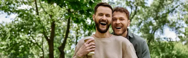 Una coppia gay barbuta ride insieme mentre si gode una giornata nel parco. — Foto stock
