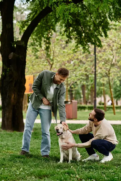 A bearded gay couple enjoys a leisurely afternoon in a green park with their labrador retriever. — Stock Photo
