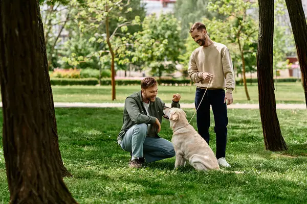 A bearded gay couple in casual attire spends quality time together with their labrador dog in a green park. — Stock Photo