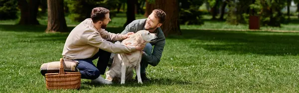 A bearded gay couple spends time together with their Labrador retriever in a green park, displaying a heartwarming display of love. — Stock Photo