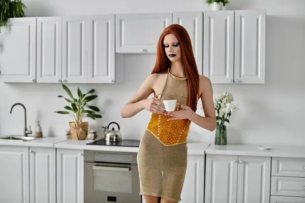 A stylish drag queen poses with a cup of tea in a modern kitchen. — Stock Photo
