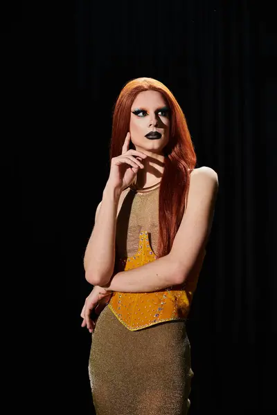 A drag diva in a shimmering gold ensemble poses backstage. — Foto stock
