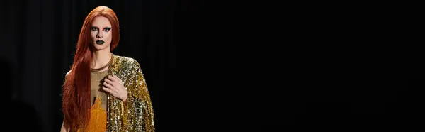 A drag performer in a gold sequined outfit stands against a dark background. — Stock Photo