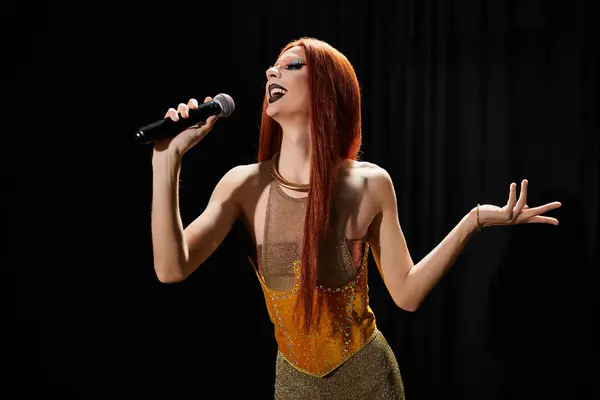A drag diva in a sparkling gold gown performs on stage, microphone in hand. — Stock Photo
