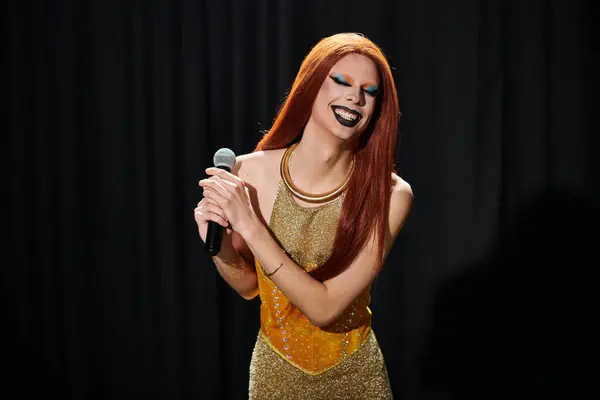 A drag queen performs on stage, holding a microphone and smiling brightly. — Stock Photo