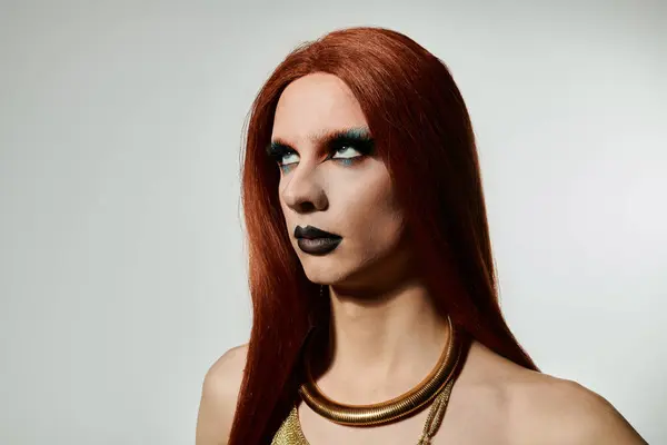 Una drag queen posa per un ritratto, in mostra un look audace trucco e scorre capelli rossi. — Foto stock