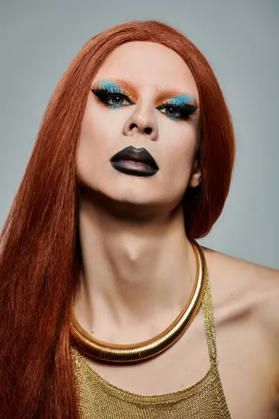 Un retrato de cerca de una drag queen con el pelo largo y rojo y maquillaje llamativo. - foto de stock