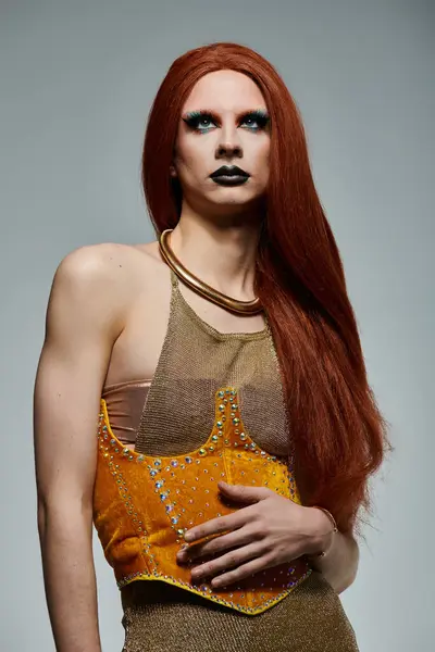 A drag queen poses in a glamorous gold and yellow outfit. — Stock Photo