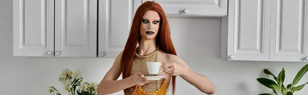 A drag queen in a glamorous outfit enjoys a cup of tea in a kitchen setting. — Stock Photo