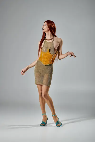 A drag queen poses in a glamorous, gold mesh dress. — Stock Photo