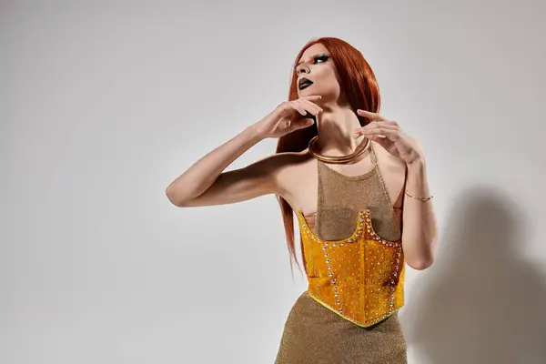 A drag diva strikes a pose in a shimmering gold outfit. — Stock Photo