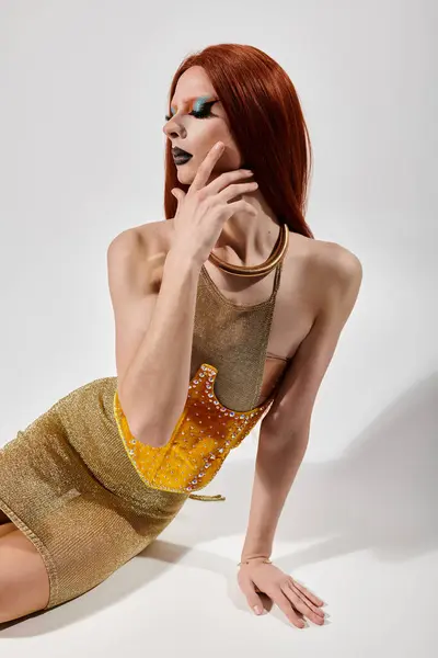 A drag queen in a sparkling golden outfit poses with a thoughtful expression. — Stock Photo