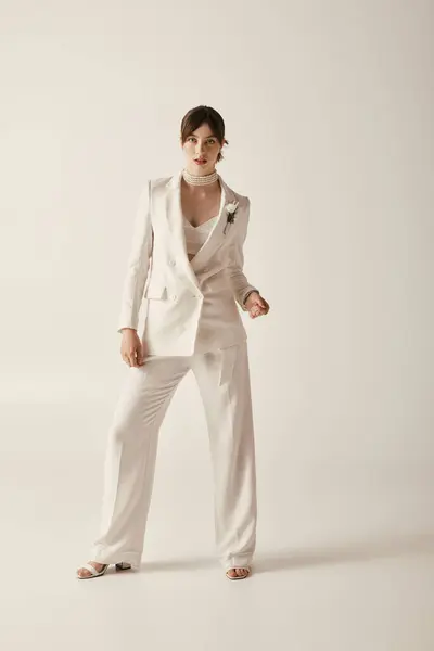 A beautiful young bride poses in a white wedding suit, exuding modern elegance. — Stock Photo