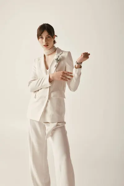 A beautiful young bride in a white suit poses against a white background. — Stock Photo