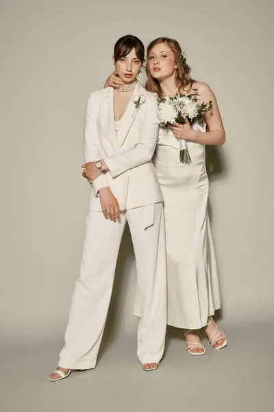 Una pareja lesbiana, vestida de blanco, celebra su boda. - foto de stock