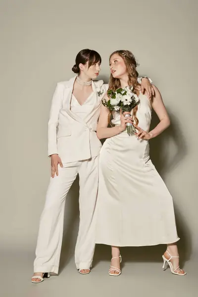 Дві жінки одягнені в білу посмішку один на одного під час весільної церемонії. — стокове фото