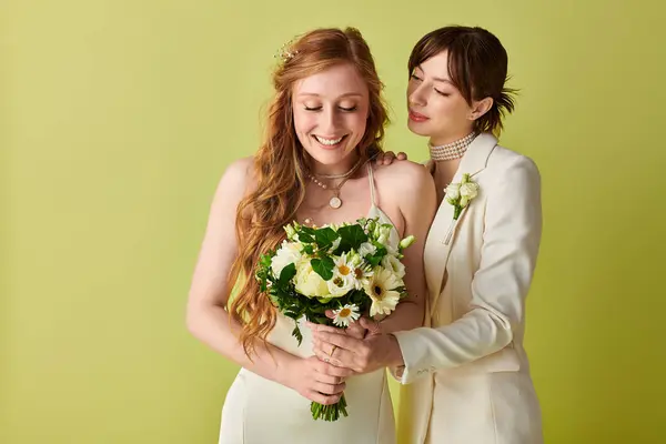 A young lesbian couple celebrates their wedding in white attire against a green backdrop, showcasing their love and commitment to one another. — Stock Photo