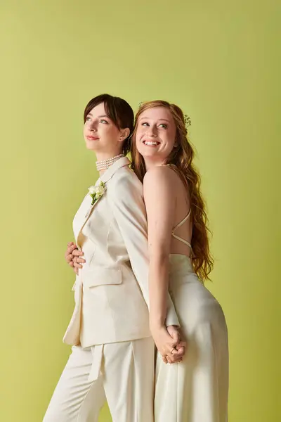 A young lesbian couple in white attire embraces during their wedding ceremony. — Stock Photo
