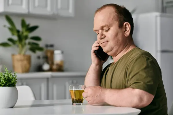A man with inclusivity sits at his kitchen table, taking a break from his day. — Stock Photo