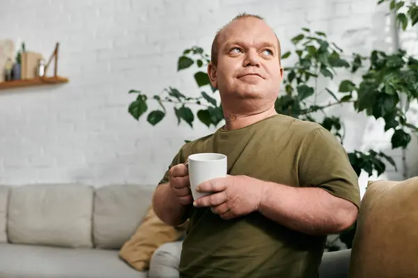 Un homme inclusif profite d'une tasse de café dans un cadre décontracté. — Photo de stock