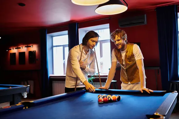 Two men play billiards, casually dressed in a stylish bar setting. — Stock Photo