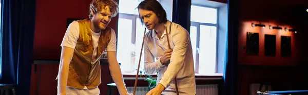 Friends play billiards in a dimly lit room, enjoying a casual game. — Stock Photo