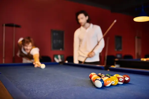 Friends play billiards in a dimly lit pub. — Stock Photo