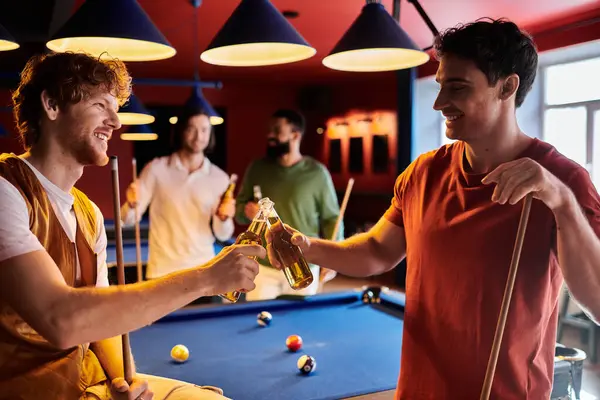 A group of friends cheers with beers after a game of pool at a bar. — Stock Photo
