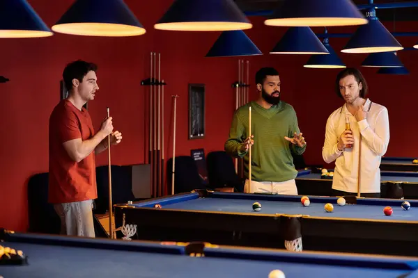 Friends enjoy a casual game of billiards in a dimly lit pool hall. — Stock Photo