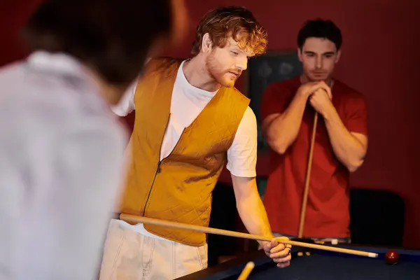 Friends play billiards in a casual setting, wearing stylish attire. — Stock Photo
