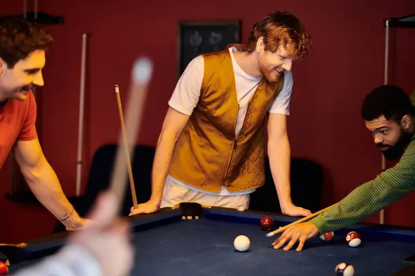 Friends play billiards in a dimly lit room, laughing and enjoying the game. — Stock Photo