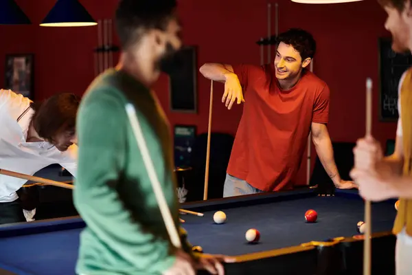 Un gruppo di amici gioca a biliardo insieme in una sala da biliardo. — Foto stock