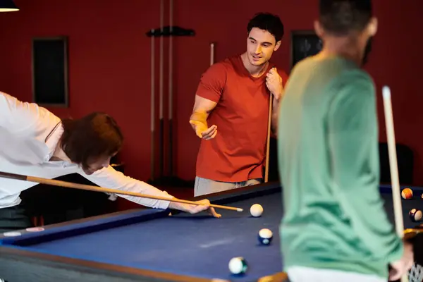 Friends play billiards in a dimly lit room, focusing on the shot. — Stock Photo