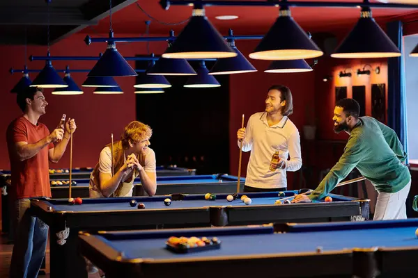 Amici in abbigliamento casual si riuniscono intorno a un tavolo da biliardo per una partita amichevole di biliardo. — Foto stock