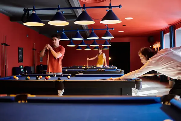 Gli amici giocano un gioco casuale di biliardo in una stanza scarsamente illuminata. — Foto stock