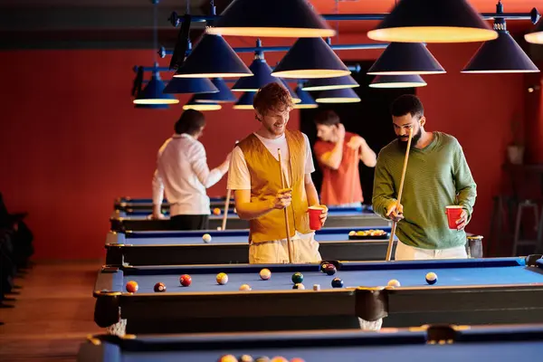 Friends are playing billiards in a dimly lit bar, with one friend taking a shot. — Stock Photo