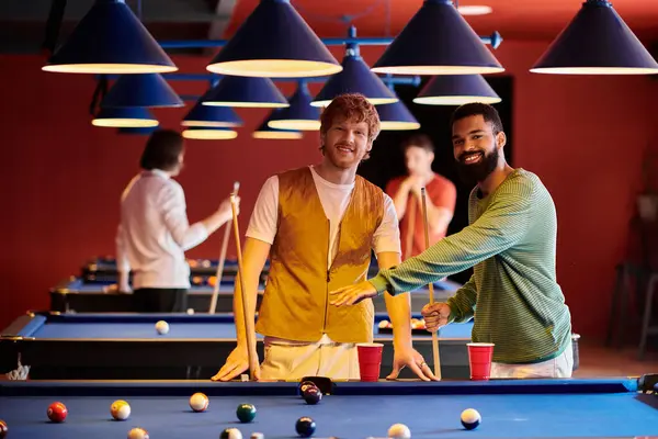 Amici giocare a biliardo insieme in un ambiente informale, in mostra una serata divertente e divertente fuori. — Foto stock