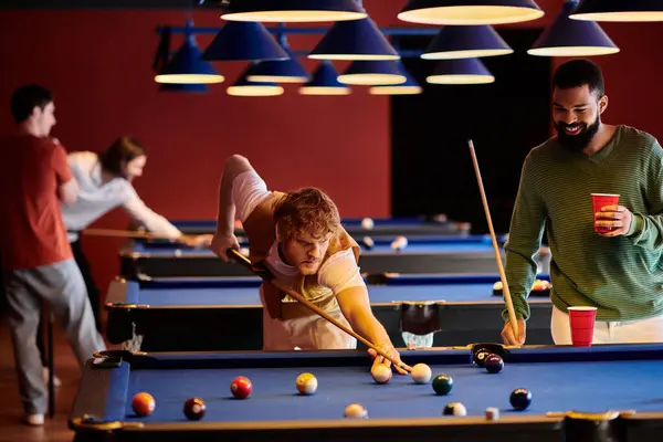 Un gruppo di amici gioca a biliardo in un ambiente elegante e contemporaneo. — Foto stock