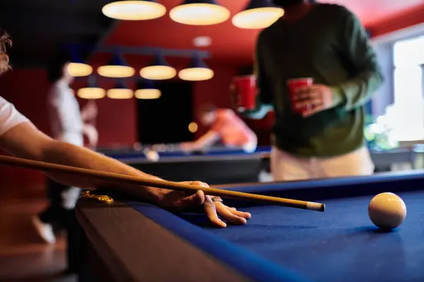 Un primo piano di un uomo che gioca a biliardo con gli amici in un ambiente casual. — Foto stock