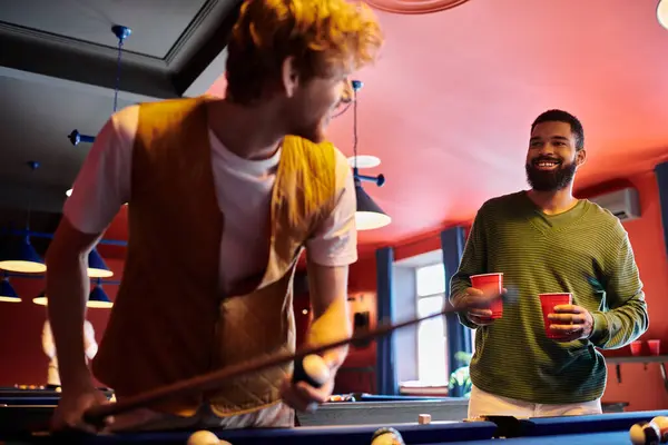 Friends play pool together in a dimly lit room. — Stock Photo